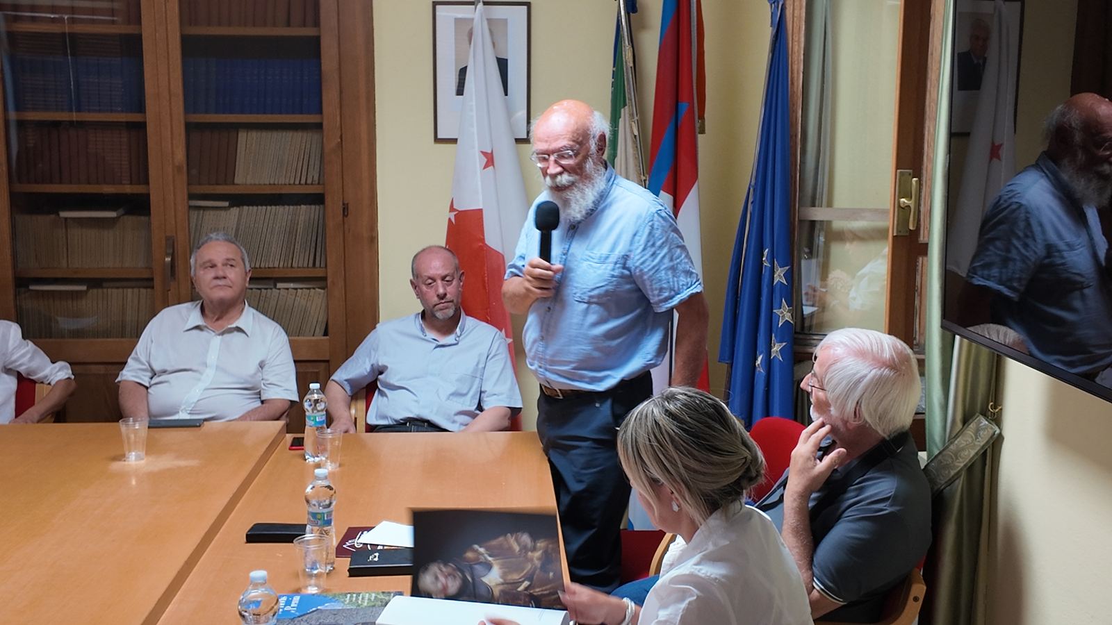 Relatore in piedi con il microfono durante l’incontro in Sala consiliare