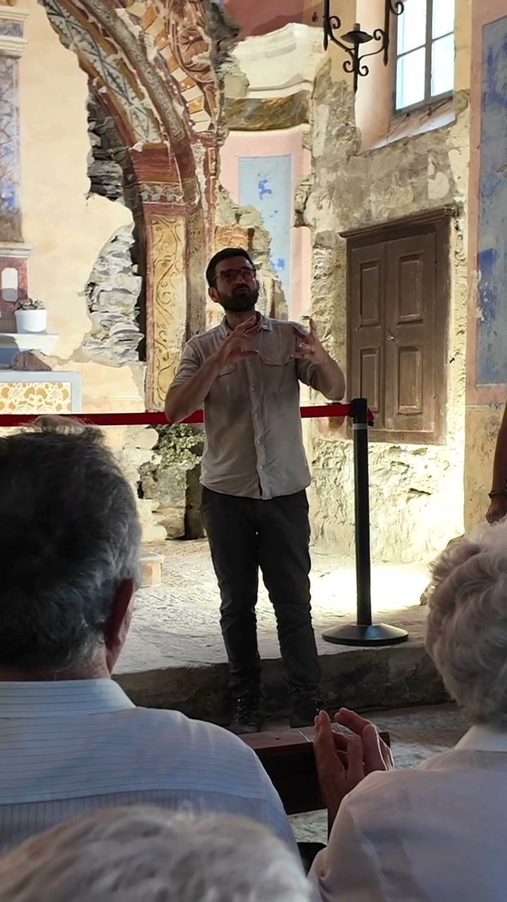 Guida che illustra gli affreschi ai visitatori dentro l’oratorio